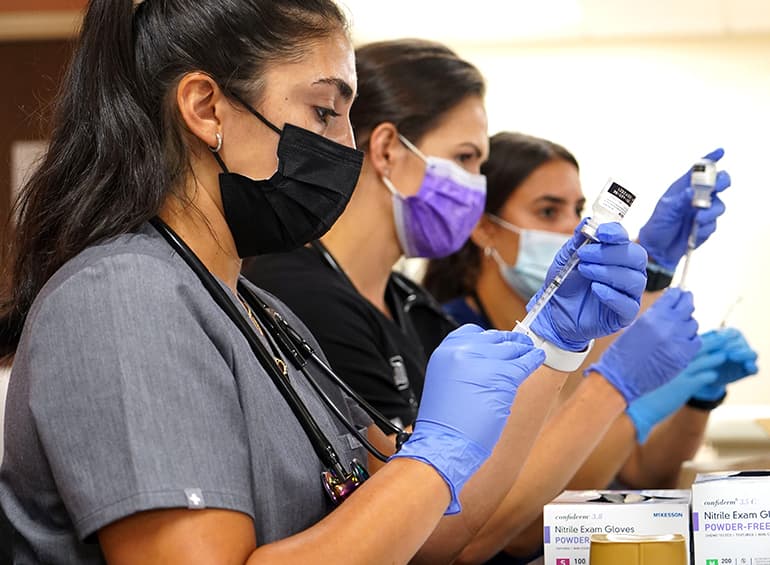 Students drawing fluids from vial